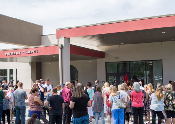 People stand in front of Idaho Arts Charter School for the ribbon cutting